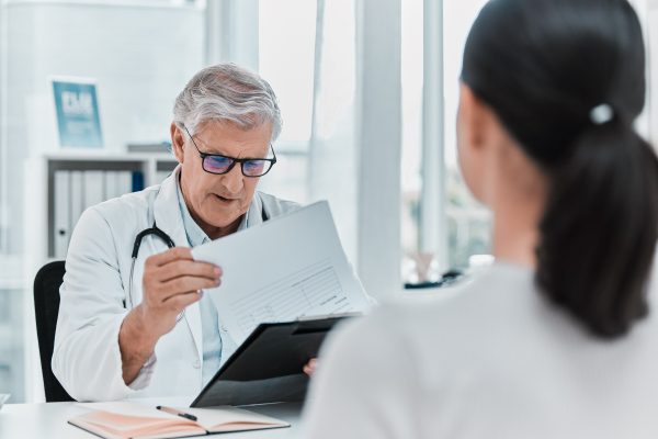 when-did-you-last-take-test-shot-mature-doctor-sitting-with-his-patient-looking-medical-chart-during-consultation-his-clinic