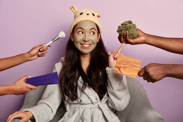 young millennial girl applies organic facial mask face after taking shower