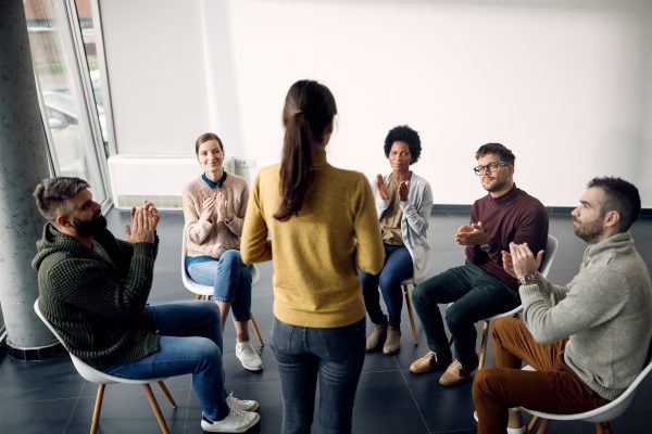 group-therapy-attenders-applauding-one-participant-during-meeting